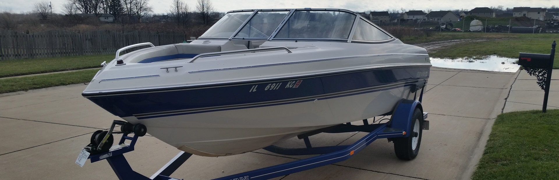 Bowrider Boat on trailer in the driveway.