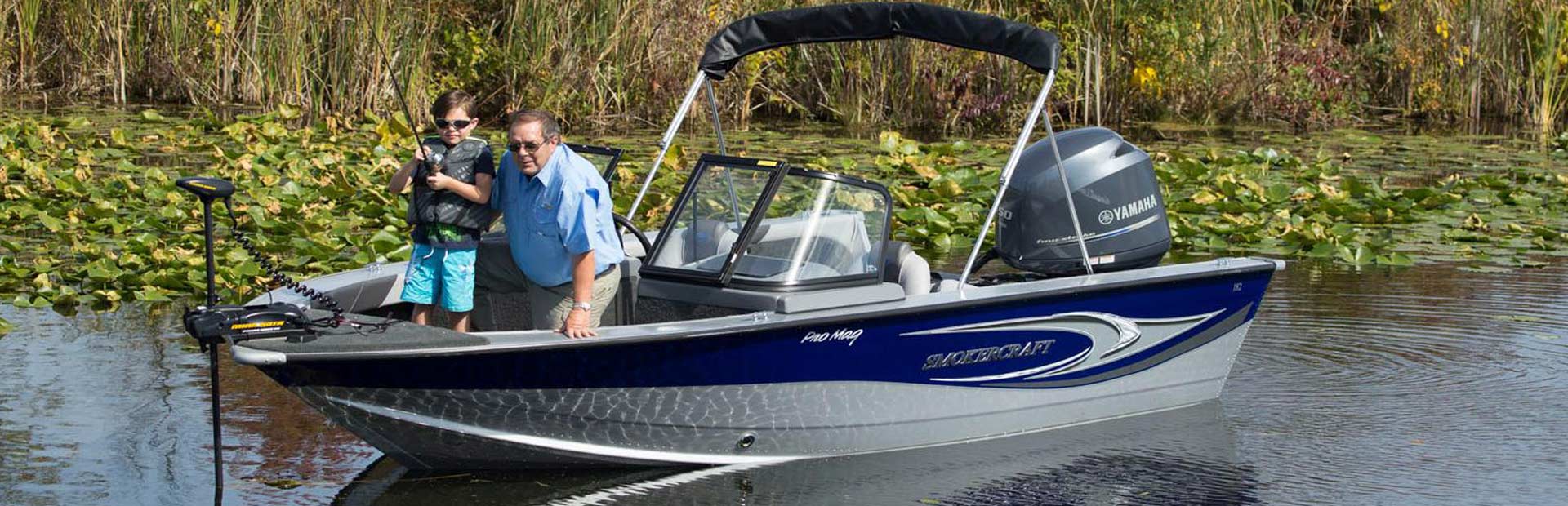 Grandpa teaching Grandson to fish on a Pro Mag Smokercraft Fishing Boat