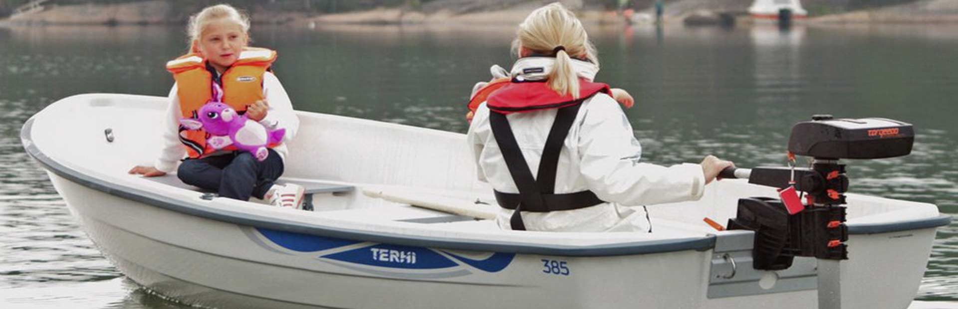 Mother and daughter in small motorboat on a lake.